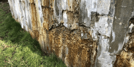 Rusty corrugated metal fence showing signs of deterioration and weathering.
